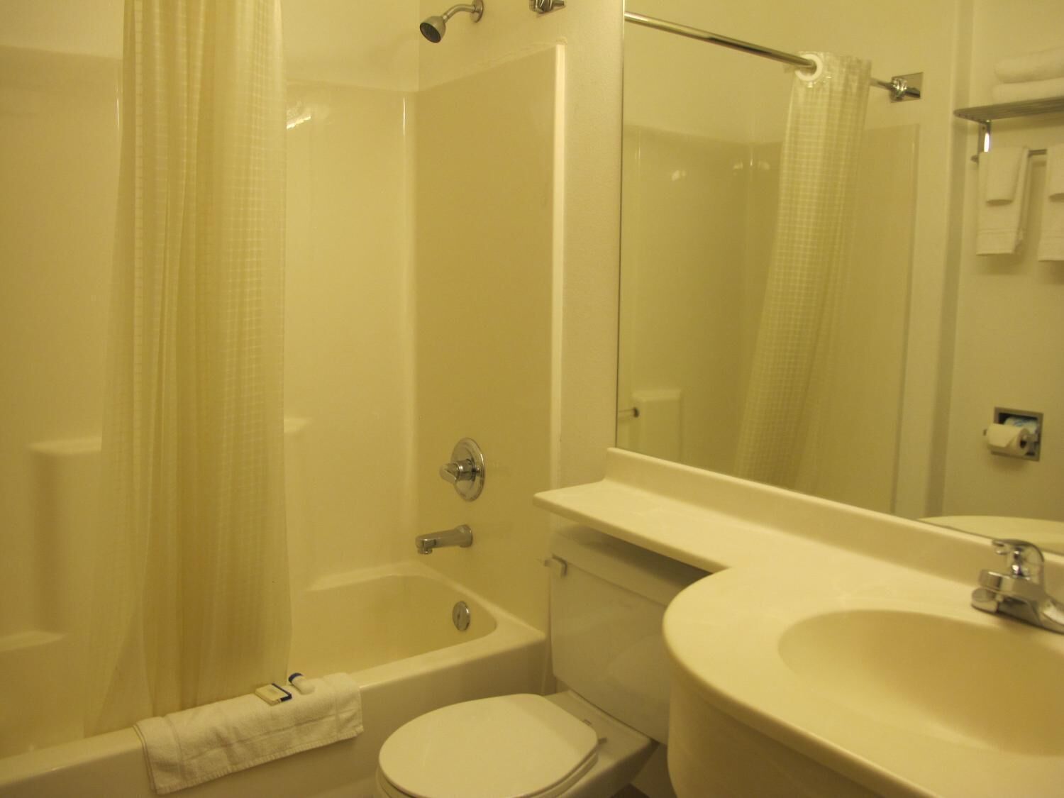 A bathroom with a bathtub, toilet, sink, and a mirror.
