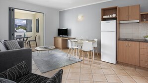 Een modern appartement met een eethoek, keuken en een balkon met uitzicht.