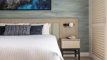 A hotel room with a bed, a nightstand, a wall-mounted lamp, and a large abstract painting.