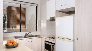 Una cocina moderna con un lavaplatos, estufa, microondas y refrigerador.