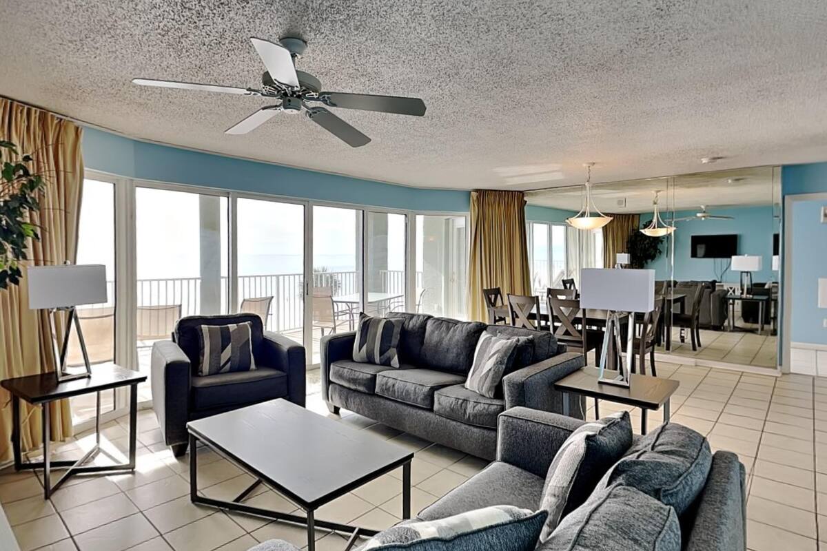 A spacious living area with a sofa set, a coffee table, and a dining area with a table and chairs.