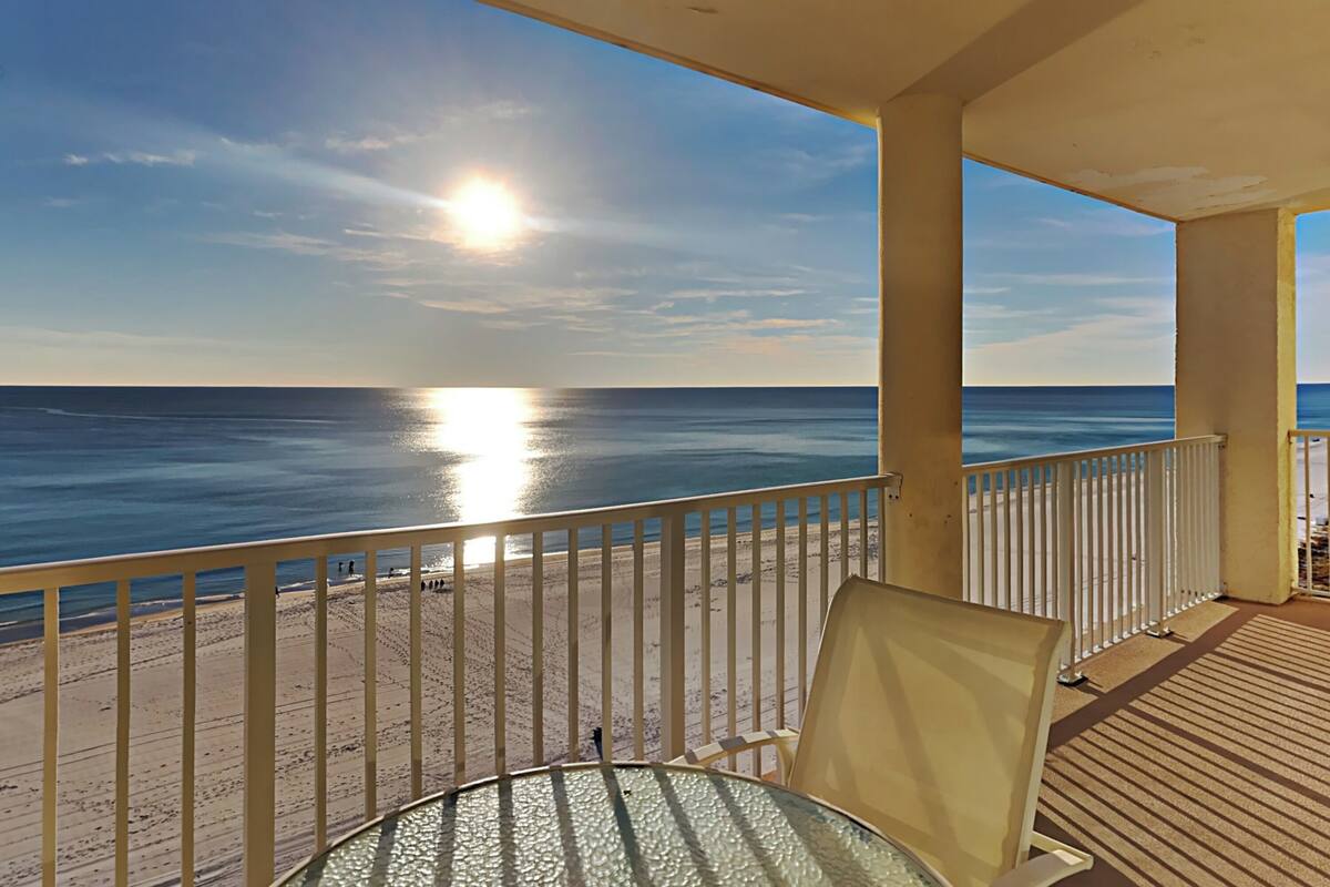 A balcony with a view of the ocean and a clear sky.