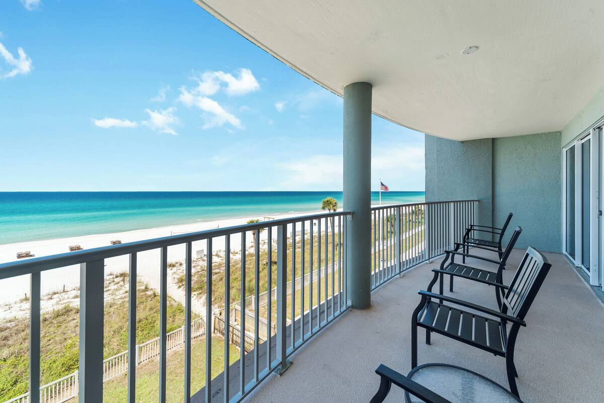 A balcony with a view of a beach and ocean.