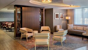 A modern hotel lobby with a seating area, a sofa, and a large window with curtains. - Fairfield Inn & Suites by Marriott Great Barrington Lenox/Berkshires (Great Barrington)