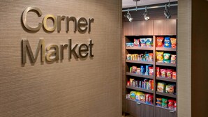 A corner market with a sign reading "the Corner Market" and shelves stocked with various snacks and groceries. - Fairfield Inn & Suites by Marriott Great Barrington Lenox/Berkshires (Great Barrington)