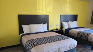 A hotel room with two beds, each with a dark headboard and white bedding. - Grapevine Inn (Lodi)