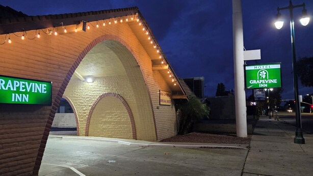 A Grapevine Inn with a brick archway and string lights. - Grapevine Inn (Lodi)