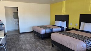 A hotel room with two beds, a desk, and a coffee machine. - Grapevine Inn (Lodi)
