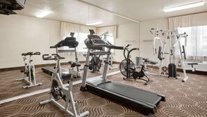 Un gimnasio de hotel con cintas de correr, bicicletas estáticas y máquinas de pesas.