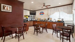 Una barra de desayuno con sillas de madera y un televisor.
