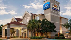 Edificio del Baymont Inn & Suites con una entrada destacada, un corredor cubierto y un césped bien cuidado.