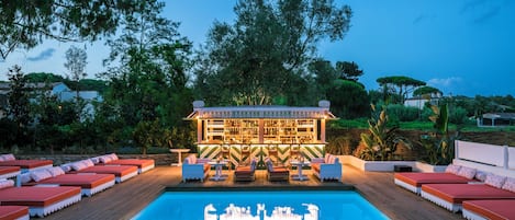 Alberca al aire libre, sombrillas en la alberca y camastros