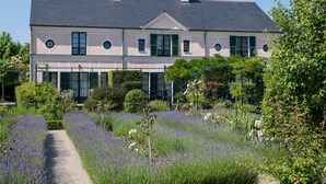 A large, two-story building with a symmetrical facade, green shutters, and a central entrance.