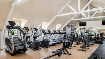 A gym with multiple treadmills, ellipticals, and weight machines.