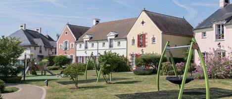 Un quartier résidentiel avec des maisons, une aire de jeux et une balançoire.