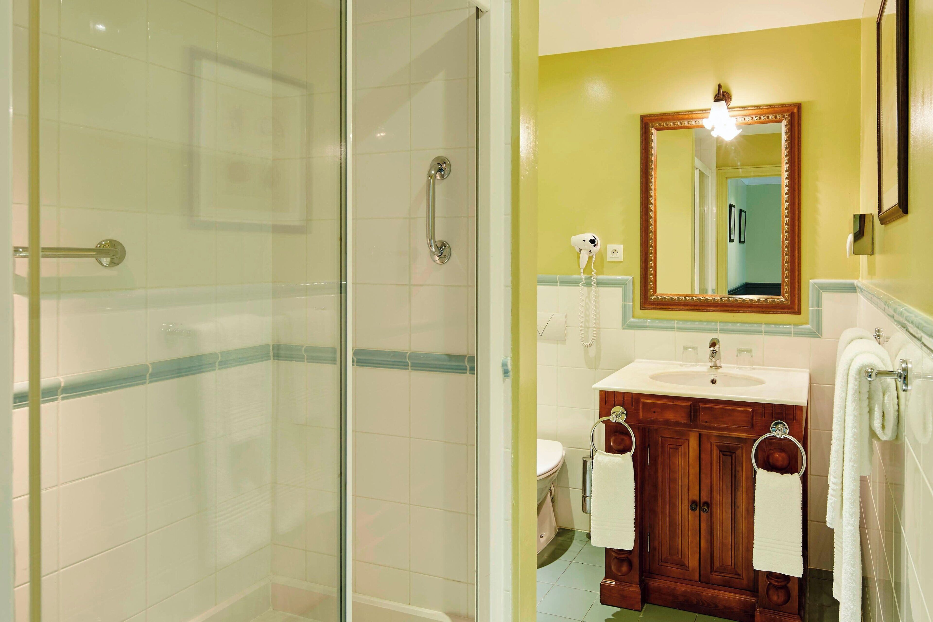 Une salle de bain avec une douche à parois de verre, un lavabo avec un meuble-vasque et un miroir au-dessus du meuble-vasque.