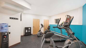 A gym with treadmills, an elliptical, and a water dispenser.