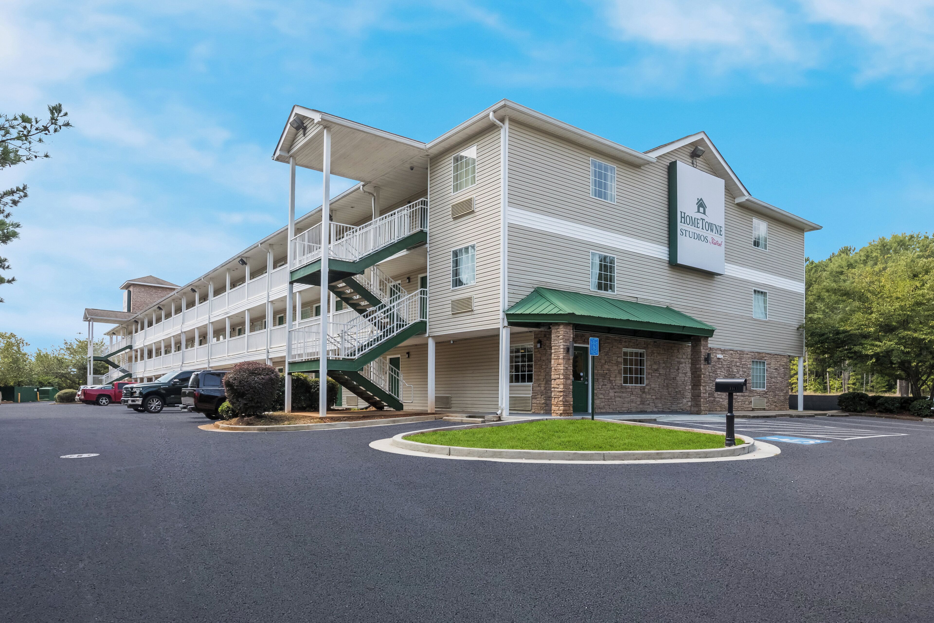 A multi-story building with a covered entrance and a staircase leading to an upper level.
