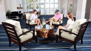 A room with four chairs around a central coffee table, large windows with a view, and a carpeted floor. - Lake Blackshear Resort & Golf Club (Cordele)