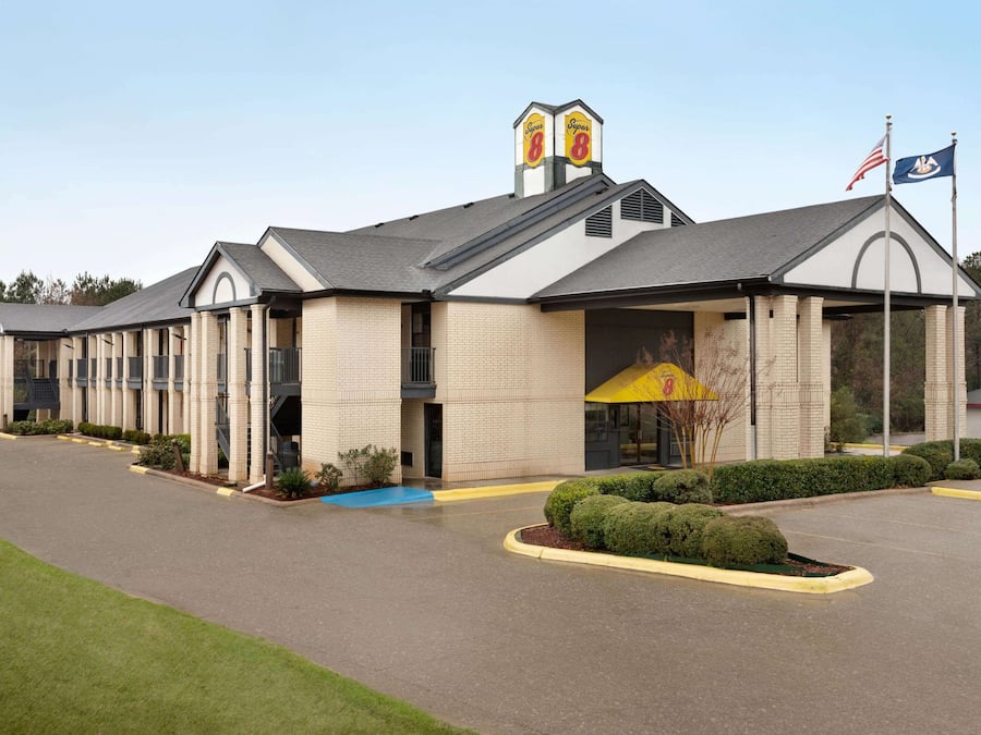 A hotel with a brick facade, a covered entrance, and a flagpole with an American flag.