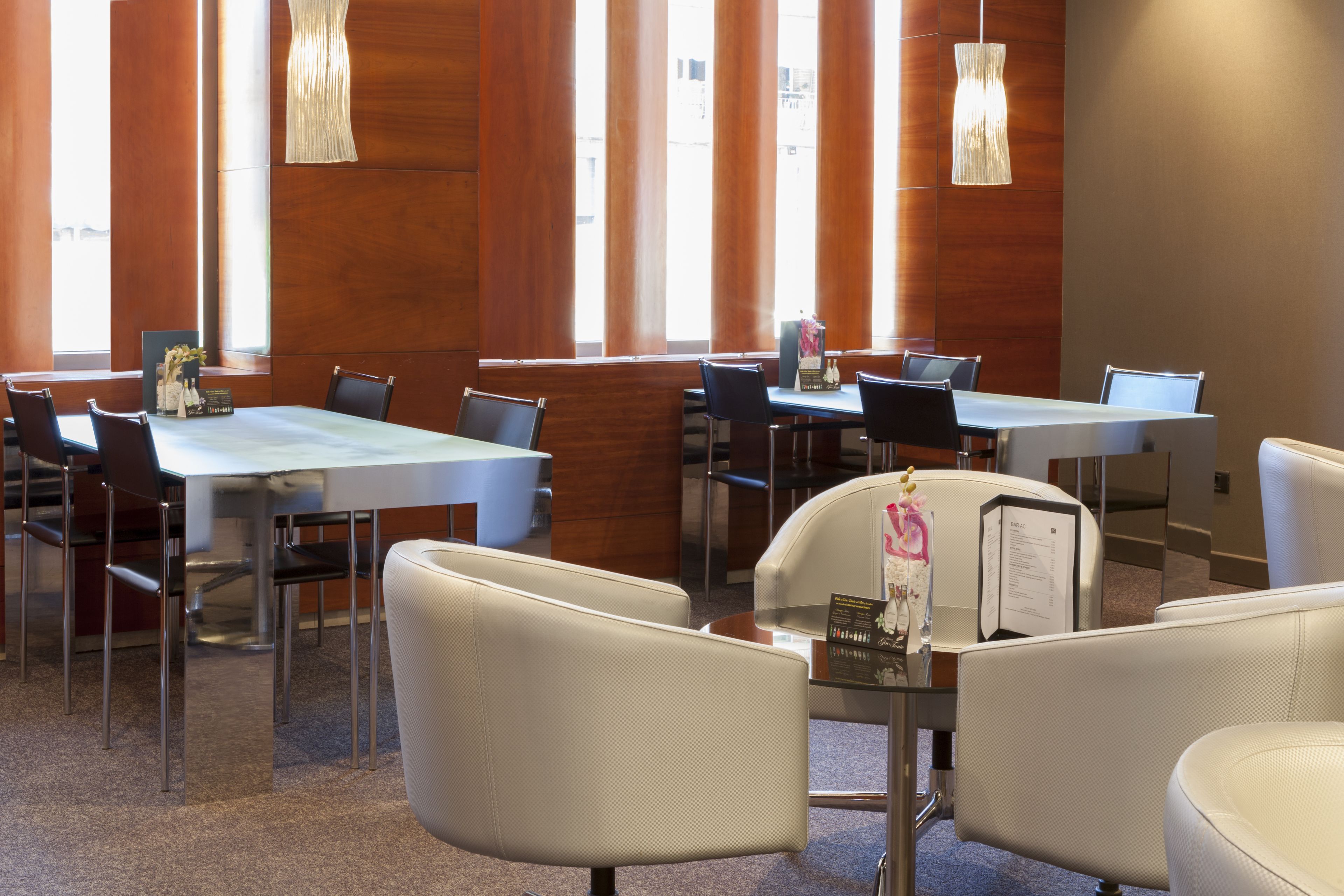 A conference room with a long table, multiple chairs, and pendant lighting.