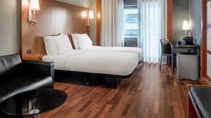 A hotel room with a large bed, a desk, a chair, and a small table. - AC Hotel Ponferrada by Marriott (Ponferrada)