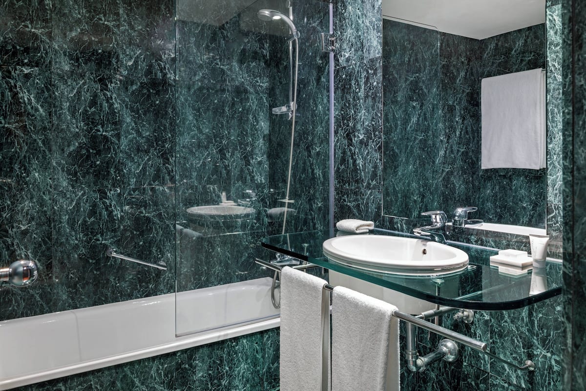 combined shower/bathtub, designer toiletries, hair dryer, towels