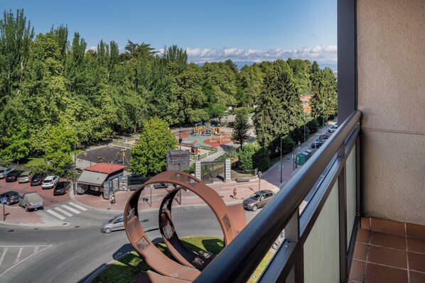 A view from a balcony overlooking a parking area, a playground, and a road with trees in the background. - AC Hotel Ponferrada by Marriott (Ponferrada)