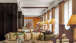 A modern hotel lobby with a sofa, a vase, and decorative lamps. - AC Hotel Ciudad de Tudela by Marriott (Tudela)