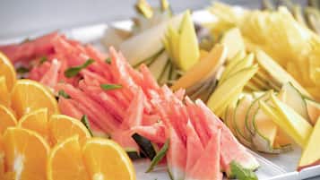 A variety of fresh fruits including watermelon, cantaloupe, and oranges arranged on a white plate.