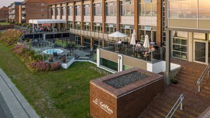 A hotel with a rooftop patio area, outdoor seating, and a swimming pool. - Griffen Spahotel (Ronne)