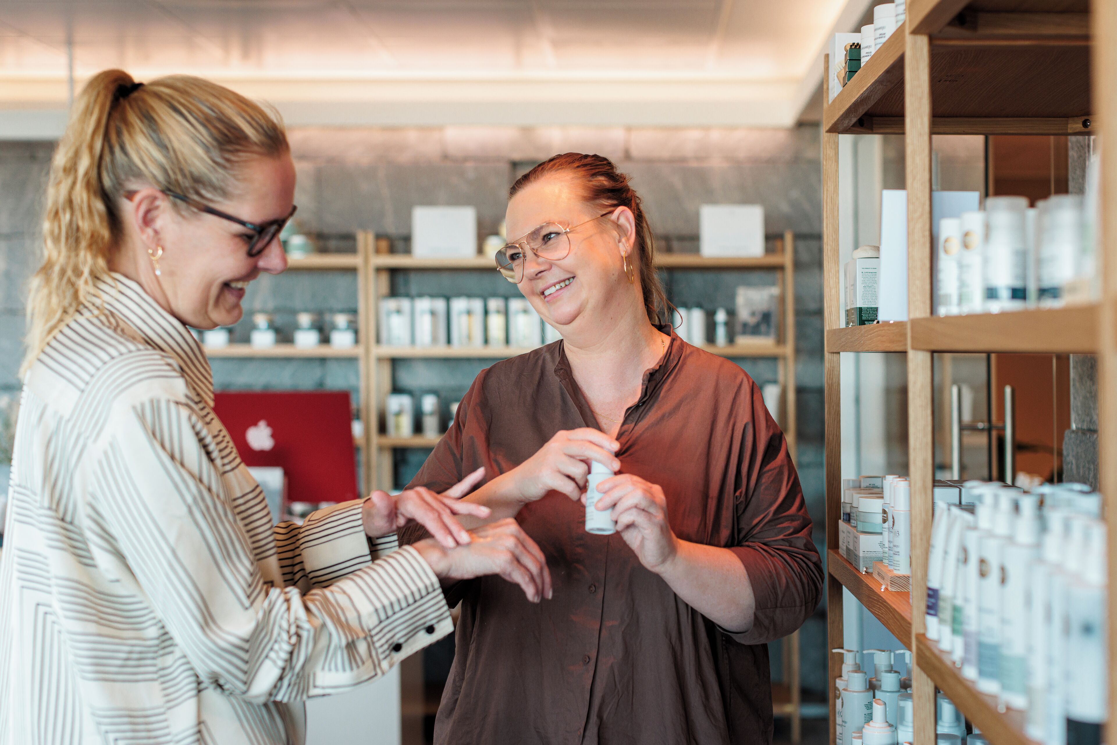 Two people in a store with shelves of products.