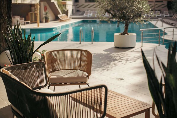 A poolside area with wicker chairs and a potted tree. - Best Western Plus Congress Hotel (Yerevan)