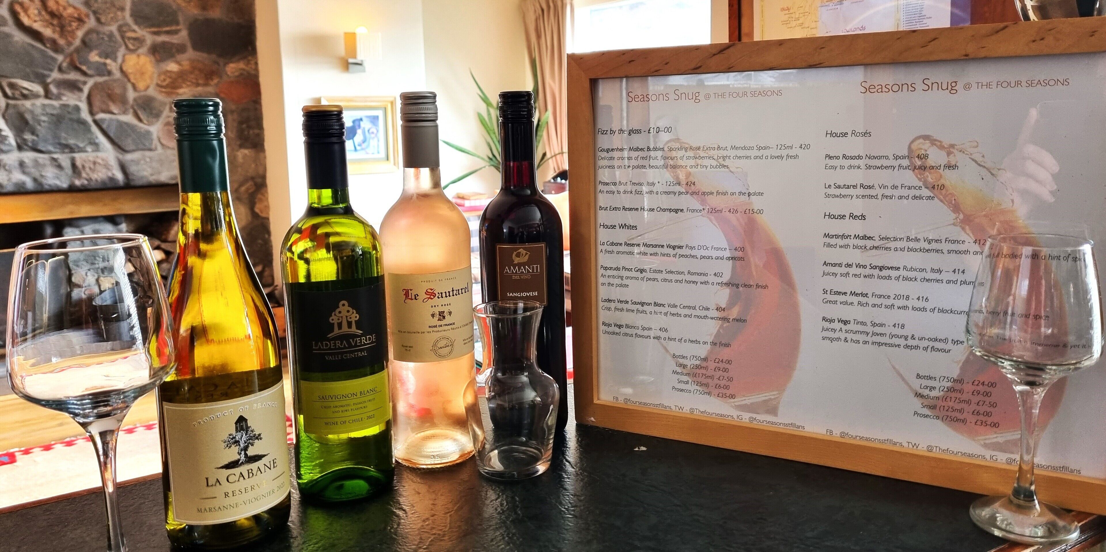 A wine tasting setup with various bottles and glasses on a counter, and a menu detailing wine selections.