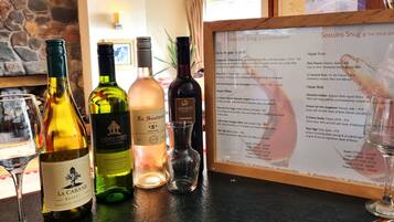 A wine tasting setup with various bottles and glasses on a counter, and a menu detailing wine selections.