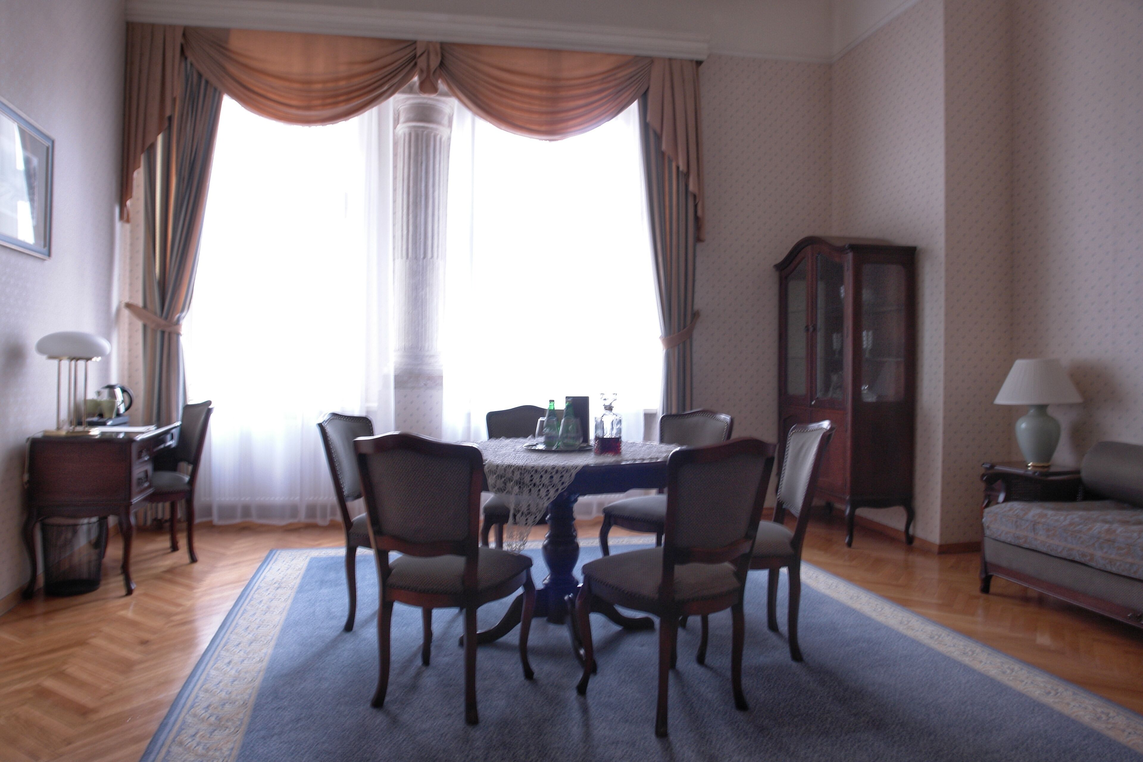 Une salle à manger avec une table ronde, quatre chaises, un buffet et un canapé.