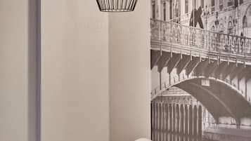 Een hotelkamer met een bed, een wandlamp en een groot gepresenteerd foto van een brug.