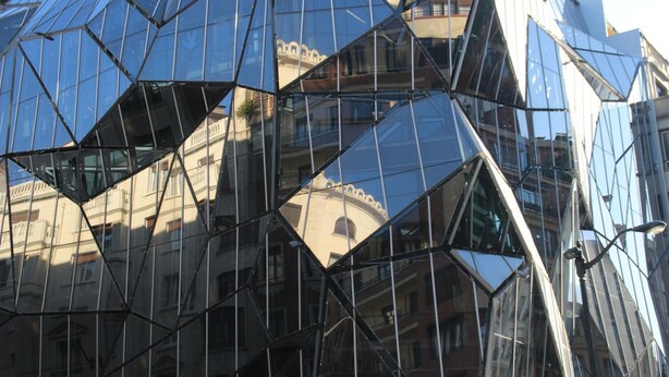 Un bâtiment moderne en verre, doté d’une façade géométrique.