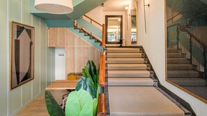 Un intérieur moderne avec un escalier, un plancher en bois et un grand miroir.