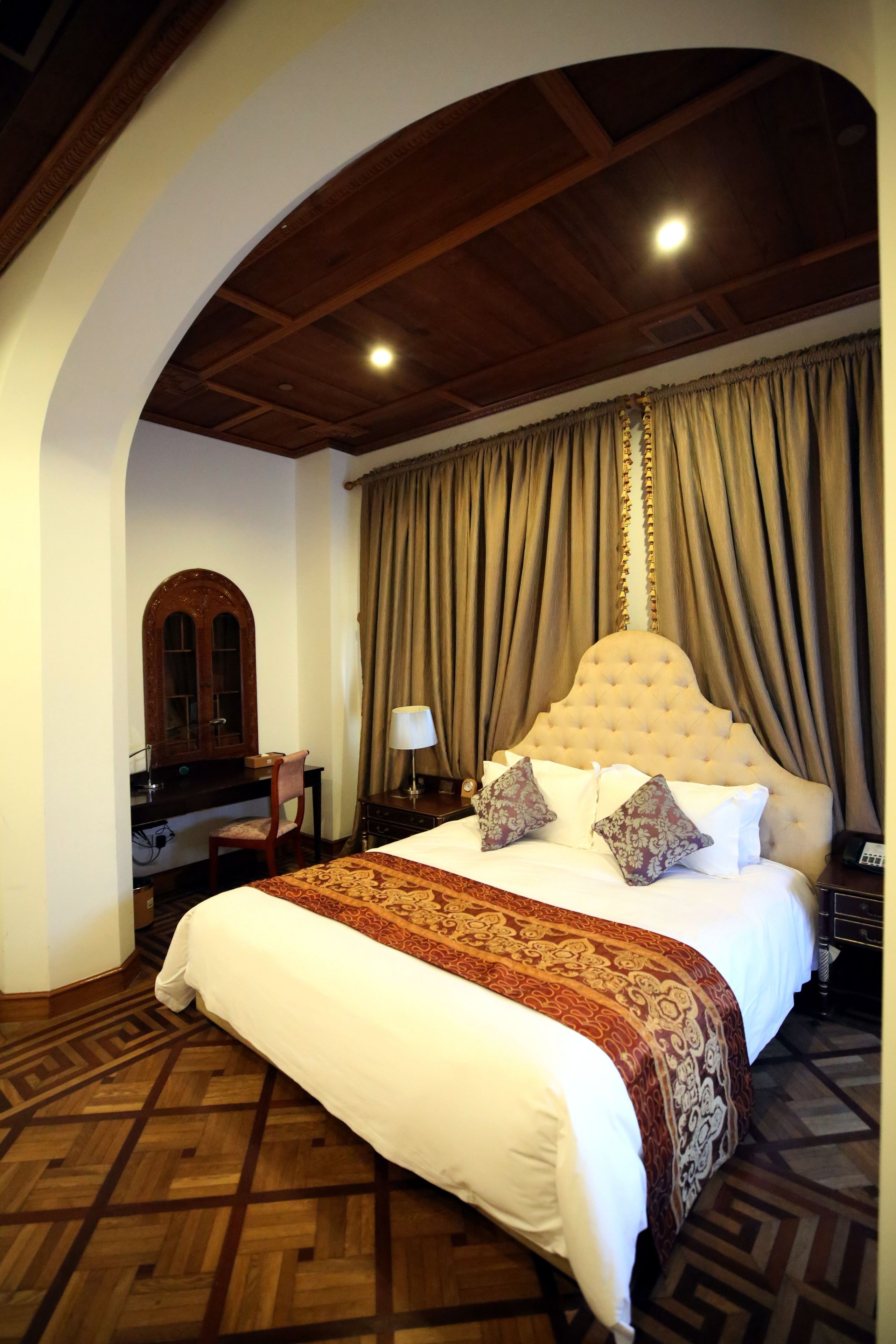 Een hotelkamer met een groot bed, een bureau en een stoel.