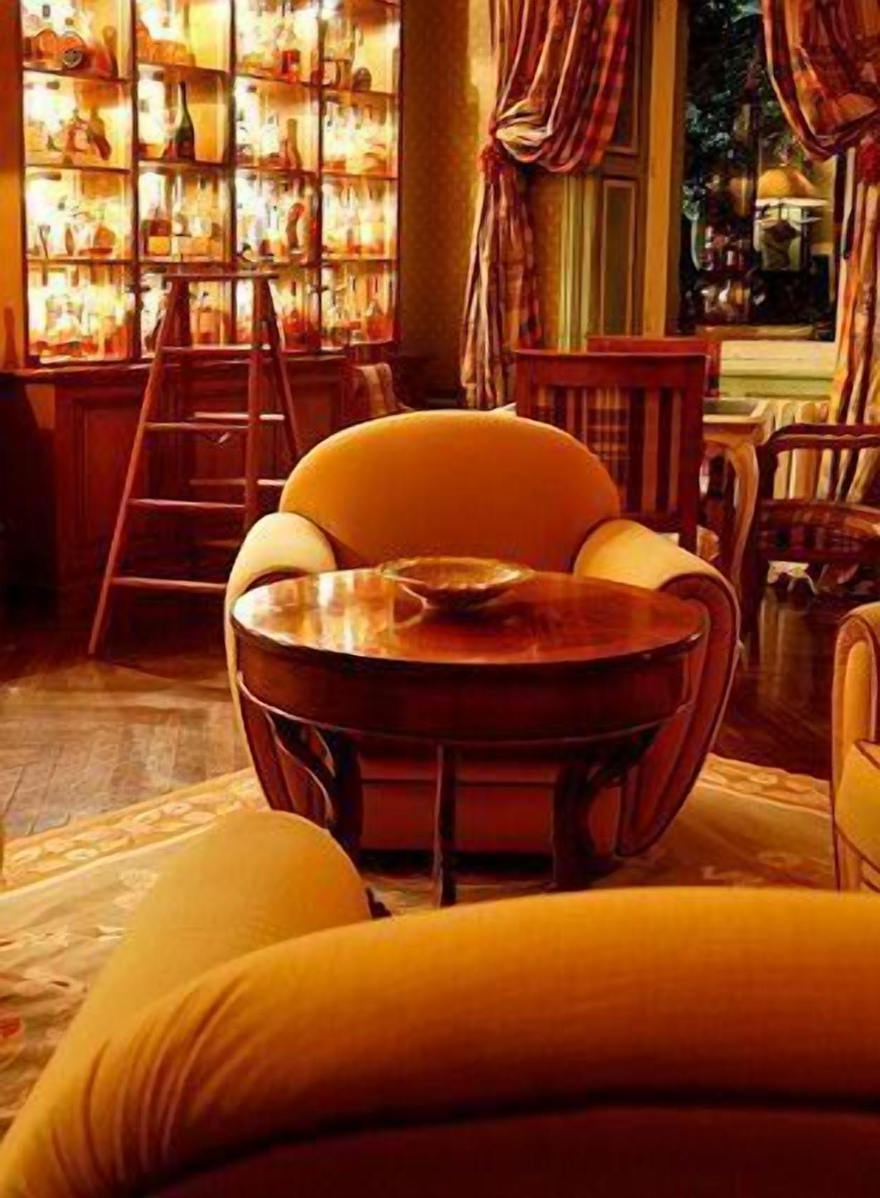 A cozy room with a round table, a chair, a ladder, and a bookshelf filled with books and decorative items.