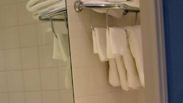 A bathroom with a yellow sink, a mirror, and a towel rack.