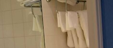 A bathroom with a yellow sink, a mirror, and a towel rack.