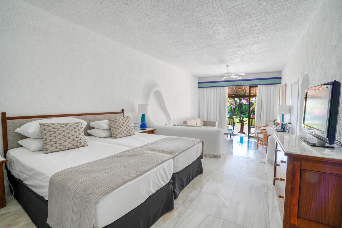 Een hotelkamer met een groot bed, een televisie, een bureau en uitzicht op de omgeving.