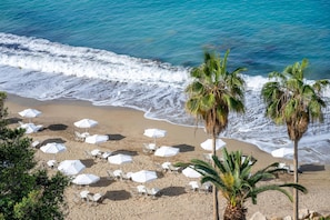 På stranden, solsenger, parasoller og strandhåndklær