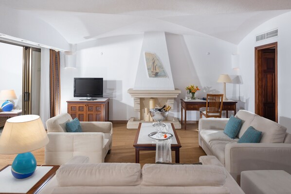 Una sala de estar con chimenea, televisor y comedor.