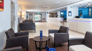 A hotel lobby with seating, a reception desk, and a sign for 'The Drinks'. - Holiday Inn Express London - Dartford by IHG (Dartford)