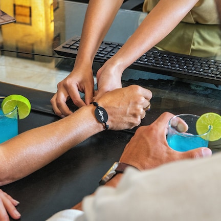 A group of people sitting around a table with drinks and a laptop.