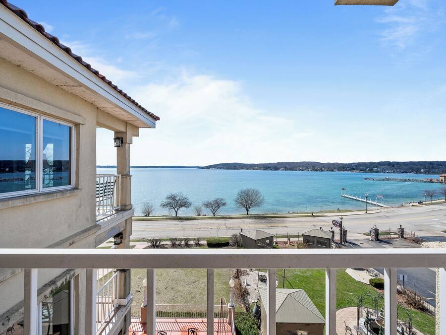 Ein Balkon mit Blick auf einen See, einen Steg und eine entfernte Uferlinie.