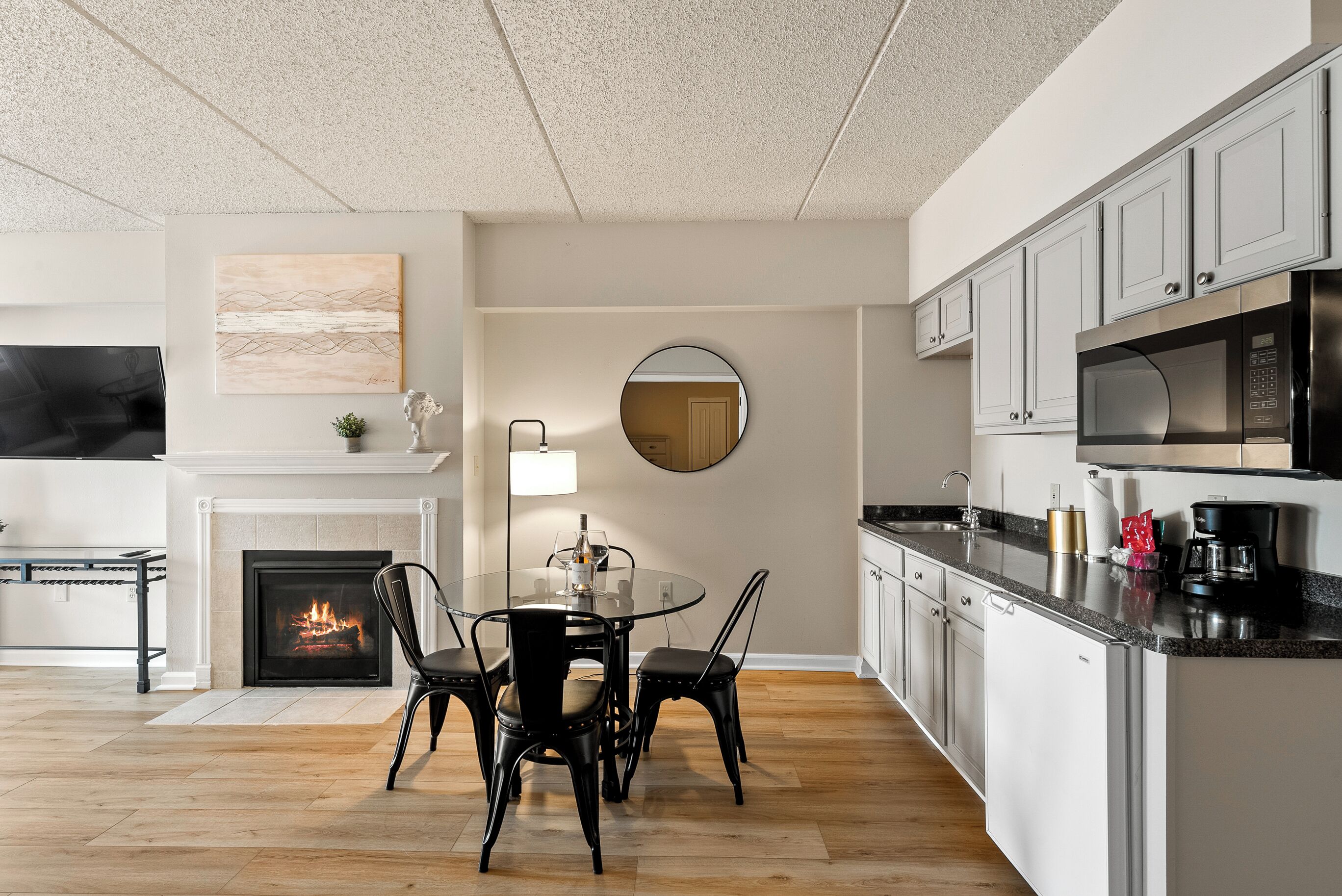 A modern kitchen with white cabinets, a black countertop, and stainless steel appliances.